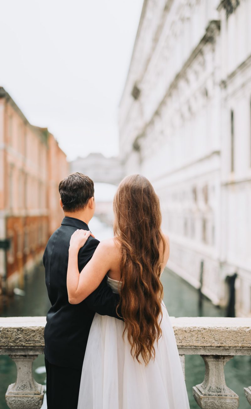 couple embracing in quiet Venetian street during honeymoon photoshoot